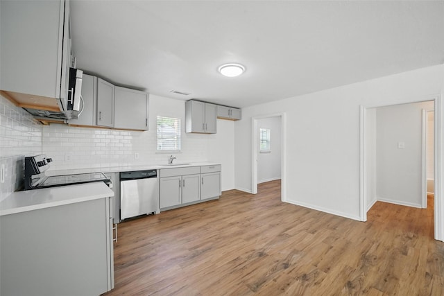 210 N 5th Ave, Denison, TX 75021 - kitchen featuring stainless steel appliances, gray cabinets, decorative backsplash, light wood-style floors, and light countertops