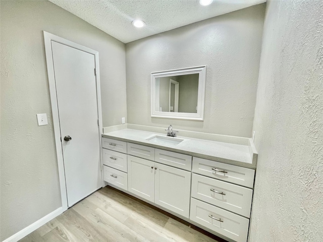 12331 Ferris Creek Ln, Dallas, TX 75243 - bathroom with vanity, wood finished floors, a textured ceiling, and a textured wall