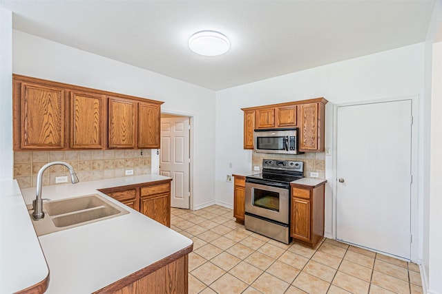 1301 Hennessey Ct, Fort Worth, TX 76131 - kitchen featuring stainless steel appliances, a sink, tasteful backsplash, brown cabinetry, and light tile patterned floors