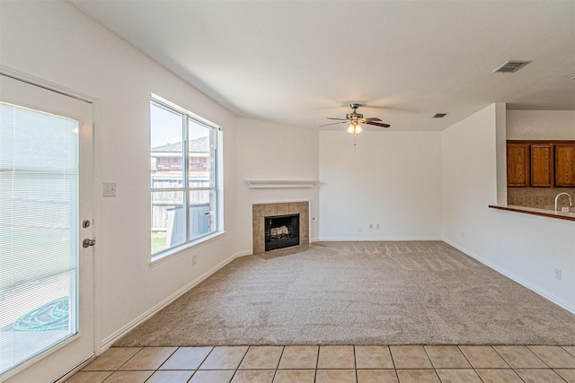 1301 Hennessey Ct, Fort Worth, TX 76131 - unfurnished living room featuring light colored carpet, ceiling fan, a fireplace, light tile patterned floors, and baseboards