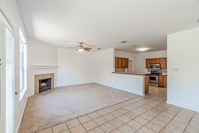 1301 Hennessey Ct, Fort Worth, TX 76131 - unfurnished living room featuring light carpet, light tile patterned floors, plenty of natural light, and a ceiling fan