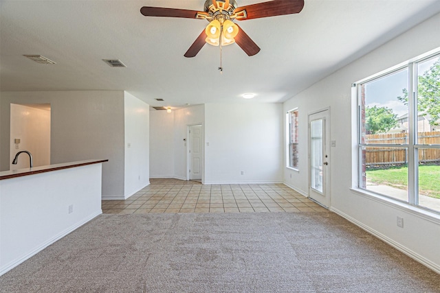 1301 Hennessey Ct, Fort Worth, TX 76131 - unfurnished living room with light tile patterned flooring, light colored carpet, ceiling fan, and healthy amount of natural light