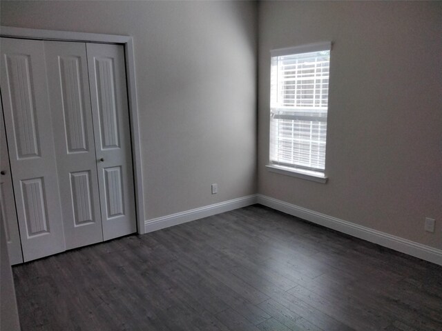 899 E Jefferson St, Van Alstyne, TX 75495 - unfurnished bedroom with dark wood finished floors, multiple windows, and baseboards