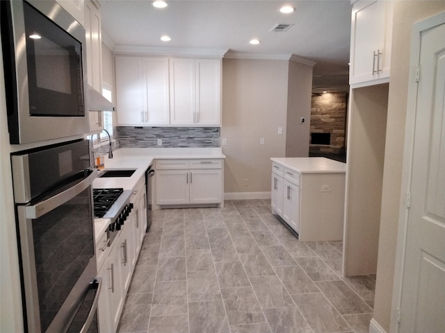 899 E Jefferson St, Van Alstyne, TX 75495 - kitchen featuring appliances with stainless steel finishes, recessed lighting, ornamental molding, light countertops, and white cabinets