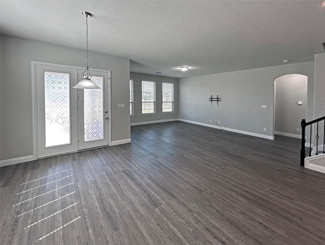 2809 Lakeside Dr, Aubrey, TX 76227 - unfurnished living room with arched walkways, a textured ceiling, dark wood finished floors, and baseboards