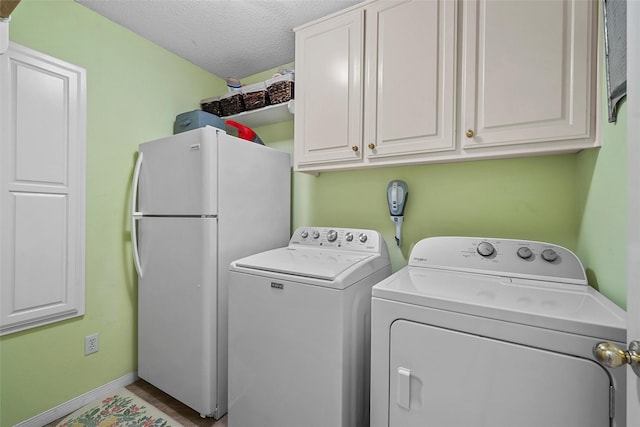 4215 Green Oak Dr, Waco, TX 76710 - washroom with washer and clothes dryer, a textured ceiling, cabinet space, and baseboards