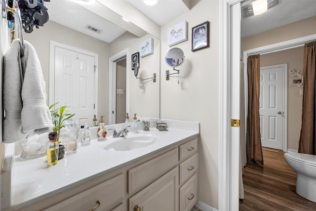 4215 Green Oak Dr, Waco, TX 76710 - bathroom with vanity, toilet, wood finished floors, and baseboards