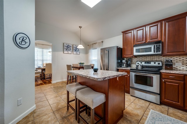 2813 Ashton Way, Mckinney, TX 75071 - kitchen with appliances with stainless steel finishes, healthy amount of natural light, lofted ceiling, light tile patterned flooring, and a kitchen bar
