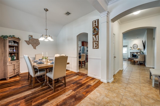 2813 Ashton Way, Mckinney, TX 75071 - dining room featuring crown molding, vaulted ceiling, arched walkways, wood finished floors, and a chandelier