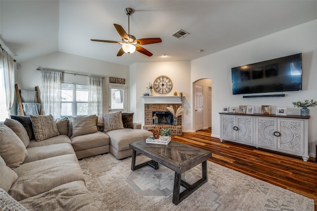 2813 Ashton Way, Mckinney, TX 75071 - living room featuring arched walkways, wood finished floors, a ceiling fan, a fireplace, and vaulted ceiling