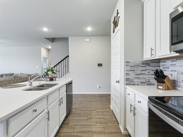 3019 Dakota Trl, Crandall, TX 75114 - kitchen featuring a sink, appliances with stainless steel finishes, decorative backsplash, light countertops, and white cabinets