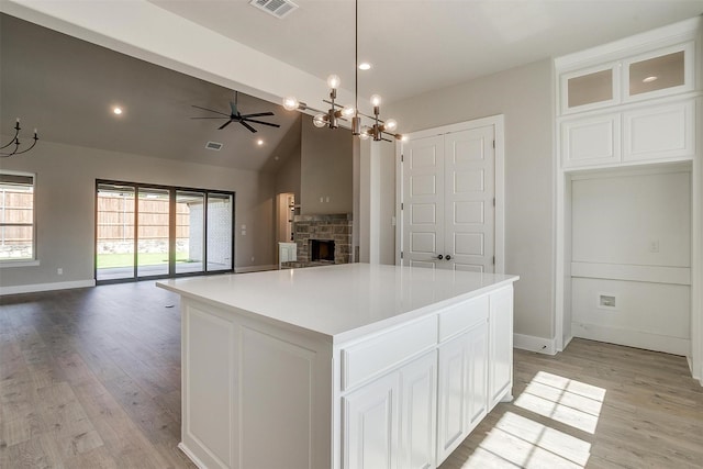 604 Bluff Point Ln, Haslet, TX 76052 - kitchen featuring open floor plan, a stone fireplace, white cabinetry, a chandelier, and vaulted ceiling