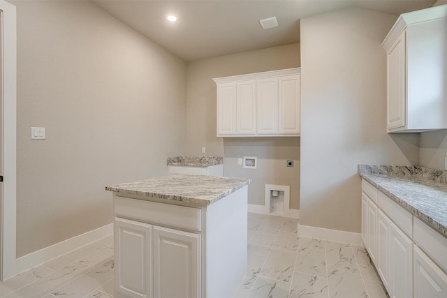 604 Bluff Point Ln, Haslet, TX 76052 - laundry area with electric dryer hookup, cabinet space, light marble finish flooring, baseboards, and recessed lighting