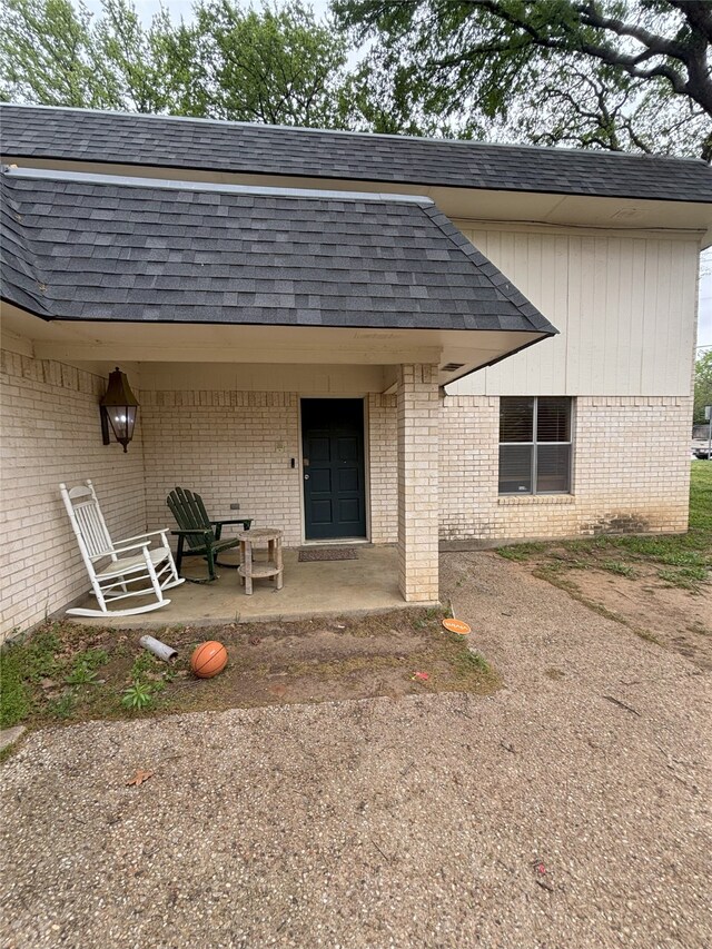 701 Rocky Canyon Rd, Arlington, TX 76012 - property entrance featuring roof with shingles and brick siding