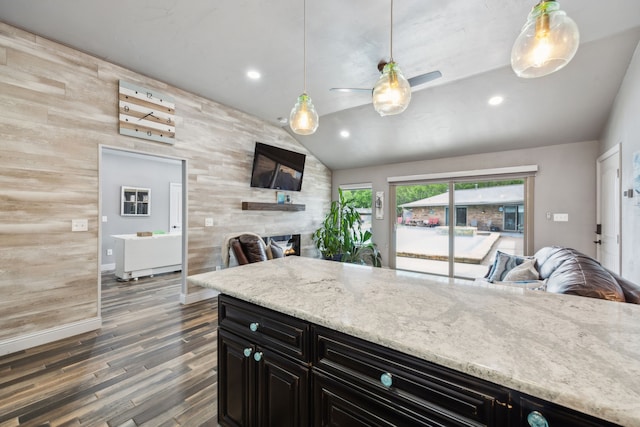 108 Circleview Dr S, Hurst, TX 76054 - kitchen featuring open floor plan, dark cabinets, lofted ceiling, wood finished floors, and wooden walls