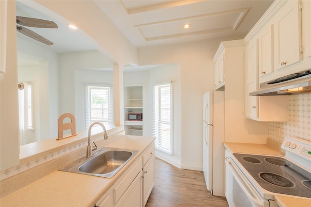 101 S Walnut St, Petrolia, TX 76377 - kitchen featuring white appliances, a sink, under cabinet range hood, light wood-type flooring, and white cabinets