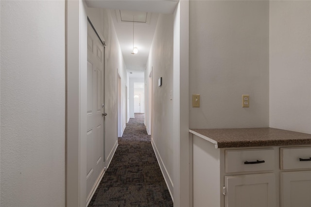 101 S Walnut St, Petrolia, TX 76377 - hallway featuring attic access and dark carpet