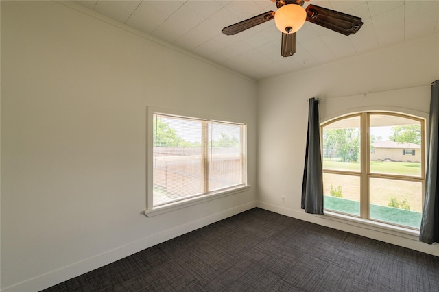 101 S Walnut St, Petrolia, TX 76377 - spare room featuring healthy amount of natural light, dark colored carpet, baseboards, and a ceiling fan