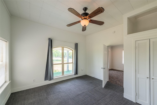 101 S Walnut St, Petrolia, TX 76377 - unfurnished bedroom with dark colored carpet, crown molding, baseboards, a ceiling fan, and a closet