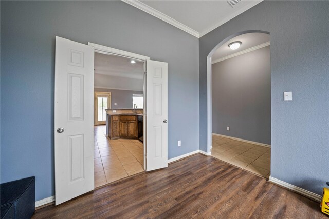 105 Universal Dr, Fate, TX 75189 - empty room with arched walkways, ornamental molding, wood finished floors, a sink, and baseboards