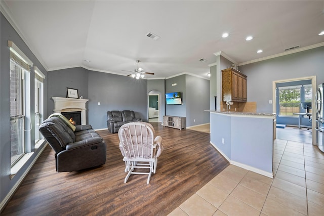 105 Universal Dr, Fate, TX 75189 - living room with a lit fireplace, recessed lighting, arched walkways, baseboards, and crown molding