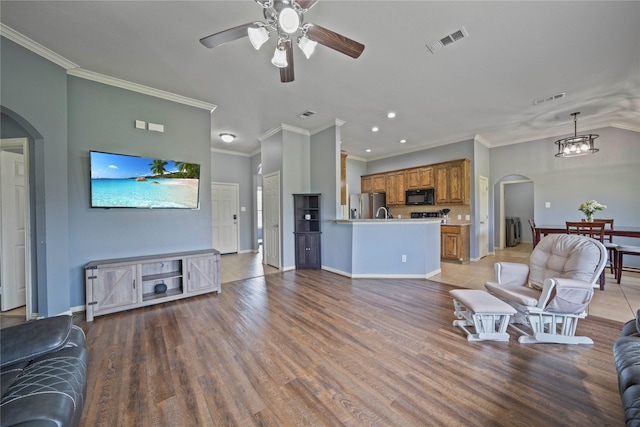 105 Universal Dr, Fate, TX 75189 - living room featuring arched walkways, ceiling fan, crown molding, light wood-type flooring, and recessed lighting