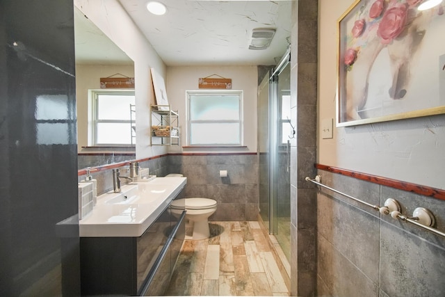 3044 US Highway 80, Grand Saline, TX 75140 - bathroom featuring tile walls, a wainscoted wall, vanity, a stall shower, and toilet