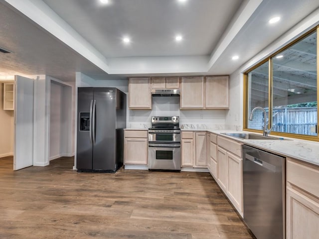 3101 Oak Hill Rd, Carrollton, TX 75007 - kitchen with stainless steel appliances, a raised ceiling, under cabinet range hood, a sink, and light brown cabinetry