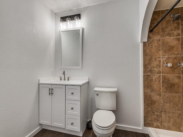 3101 Oak Hill Rd, Carrollton, TX 75007 - full bath featuring vanity, wood finished floors, toilet, a tile shower, and a textured wall