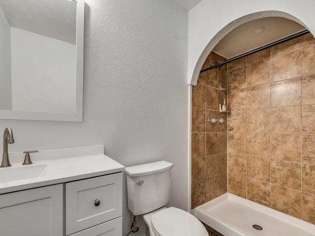3101 Oak Hill Rd, Carrollton, TX 75007 - bathroom featuring toilet, vanity, tiled shower, and a textured wall