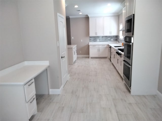 901 E Jefferson St, Van Alstyne, TX 75495 - kitchen featuring decorative backsplash, appliances with stainless steel finishes, white cabinetry, ornamental molding, and baseboards