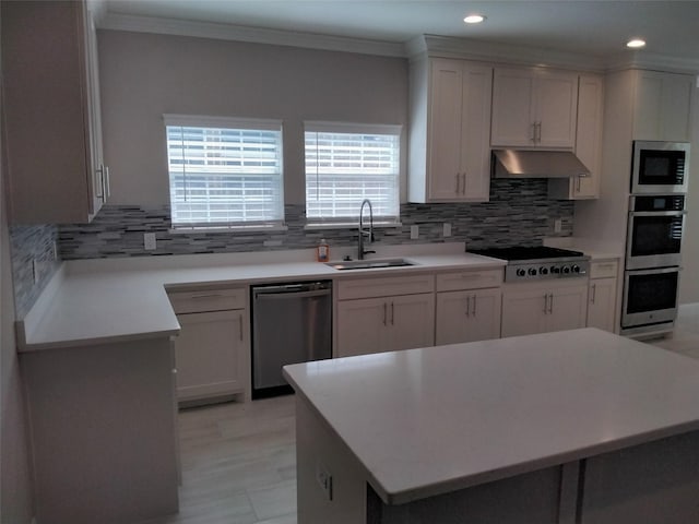 901 E Jefferson St, Van Alstyne, TX 75495 - kitchen with appliances with stainless steel finishes, a sink, under cabinet range hood, tasteful backsplash, and recessed lighting