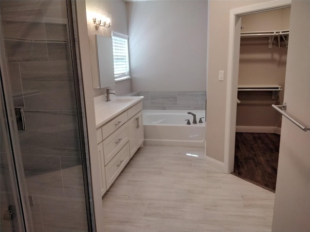 901 E Jefferson St, Van Alstyne, TX 75495 - bathroom featuring vanity, a bath, a spacious closet, and a shower stall