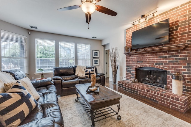 5801 Maidstone Dr, Richardson, TX 75082 - living room with plenty of natural light, a ceiling fan, wood finished floors, and a brick fireplace
