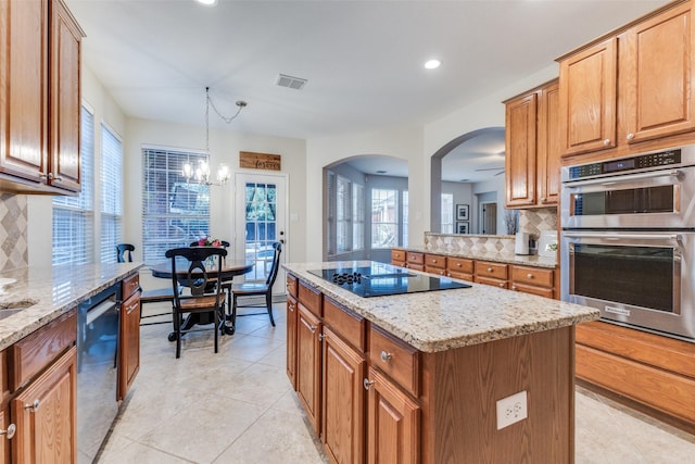 5801 Maidstone Dr, Richardson, TX 75082 - kitchen with black electric cooktop, stainless steel double oven, dishwashing machine, tasteful backsplash, and arched walkways