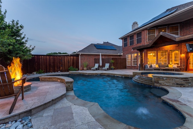 5801 Maidstone Dr, Richardson, TX 75082 - pool at dusk with a fire pit, a patio, a fenced backyard, and a pool with connected hot tub