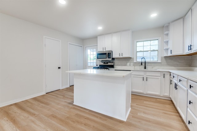 3524 Swan St, Haltom City, TX 76117 - kitchen featuring stainless steel microwave, a sink, a center island, decorative backsplash, and recessed lighting