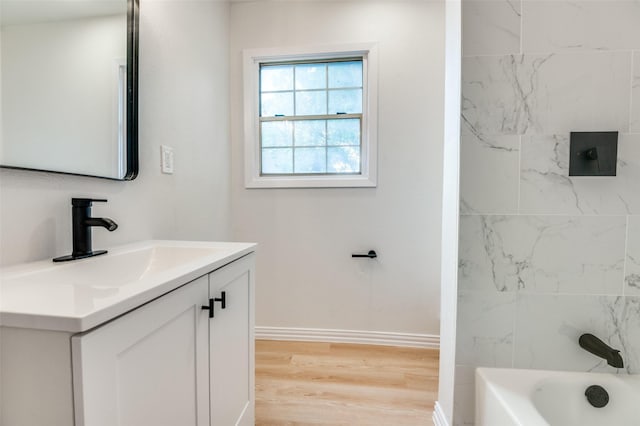 3524 Swan St, Haltom City, TX 76117 - bathroom featuring vanity, wood finished floors, baseboards, and bathing tub / shower combination