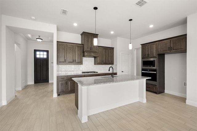 366 Paddle Boat Dr, Granbury, TX 76048 - kitchen with appliances with stainless steel finishes, a sink, light wood-style floors, dark brown cabinetry, and recessed lighting