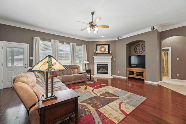 7917 Chapelwood Dr, North Richland Hills, TX 76182 - living area with arched walkways, ceiling fan, ornamental molding, wood finished floors, and a glass covered fireplace
