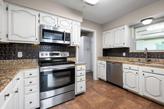 310 Singletree St, Highland Village, TX 75077 - kitchen with appliances with stainless steel finishes, a sink, tasteful backsplash, white cabinets, and stone countertops