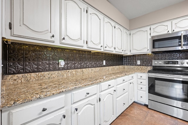 310 Singletree St, Highland Village, TX 75077 - kitchen featuring stainless steel appliances, decorative backsplash, and white cabinetry