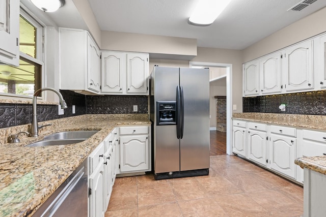 310 Singletree St, Highland Village, TX 75077 - kitchen with stainless steel appliances, a sink, white cabinets, backsplash, and light stone countertops