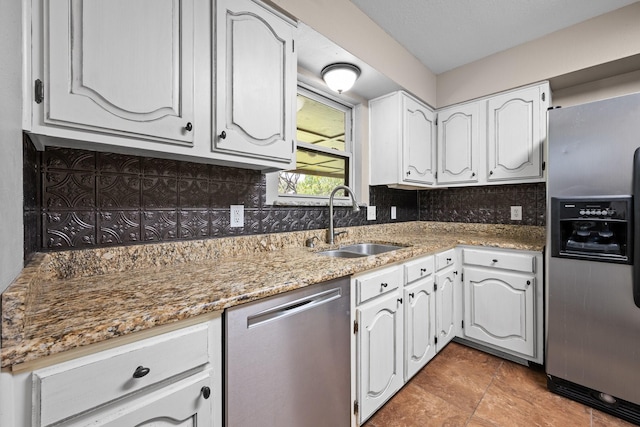 310 Singletree St, Highland Village, TX 75077 - kitchen with stainless steel appliances, a sink, tasteful backsplash, and white cabinets