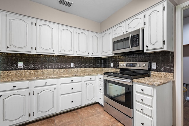310 Singletree St, Highland Village, TX 75077 - kitchen with stainless steel appliances, backsplash, and white cabinetry