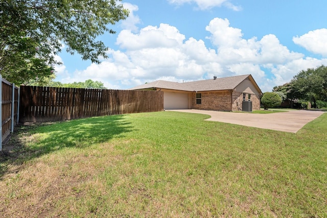 310 Singletree St, Highland Village, TX 75077 - view of yard with central AC unit, concrete driveway, and an attached garage