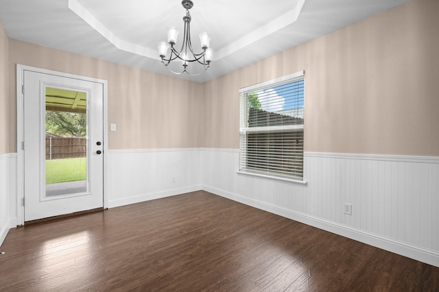 310 Singletree St, Highland Village, TX 75077 - unfurnished dining area featuring a chandelier, wainscoting, dark wood-type flooring, and a raised ceiling