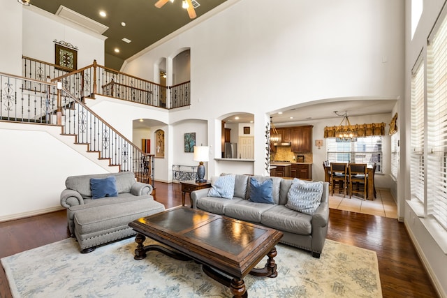 1765 Mustang Trl, Frisco, TX 75033 - living room with dark wood-type flooring, stairway, a towering ceiling, arched walkways, and baseboards