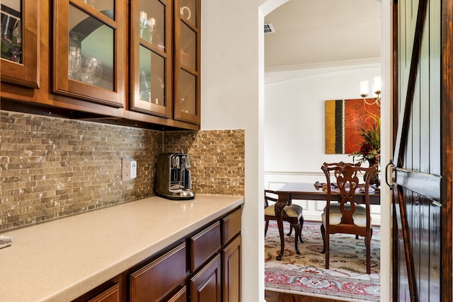 1765 Mustang Trl, Frisco, TX 75033 - bar area with decorative backsplash, arched walkways, crown molding, and a chandelier