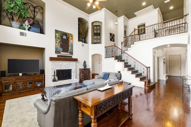 1765 Mustang Trl, Frisco, TX 75033 - living room with arched walkways, a high ceiling, stairs, wood finished floors, and ceiling fan